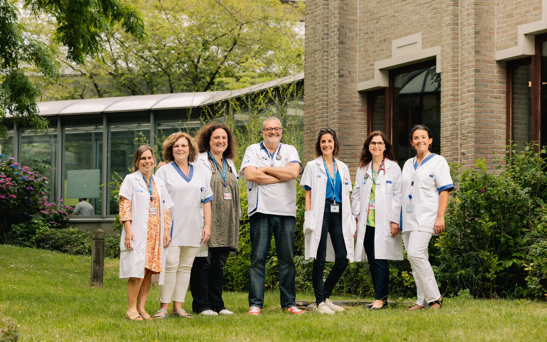 Équipe pluridisciplinaire de soignants dans le jardin d'un hôpital — portrait d'équipe médicale