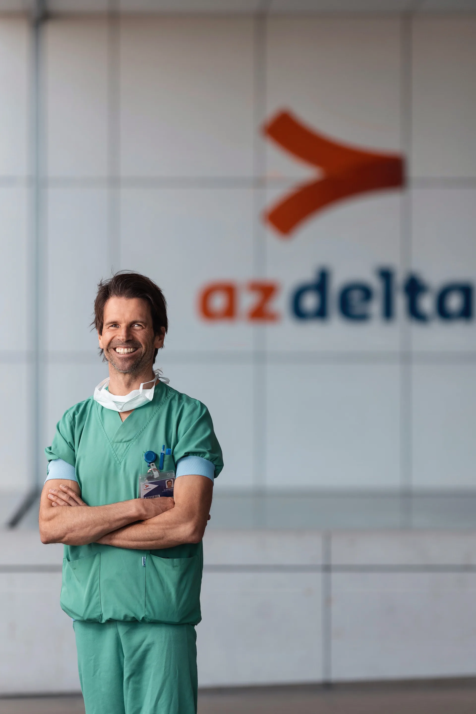 Portrait d'un médecin en tenue de bloc devant le logo AZ Delta — photographie médicale ALTABENA
